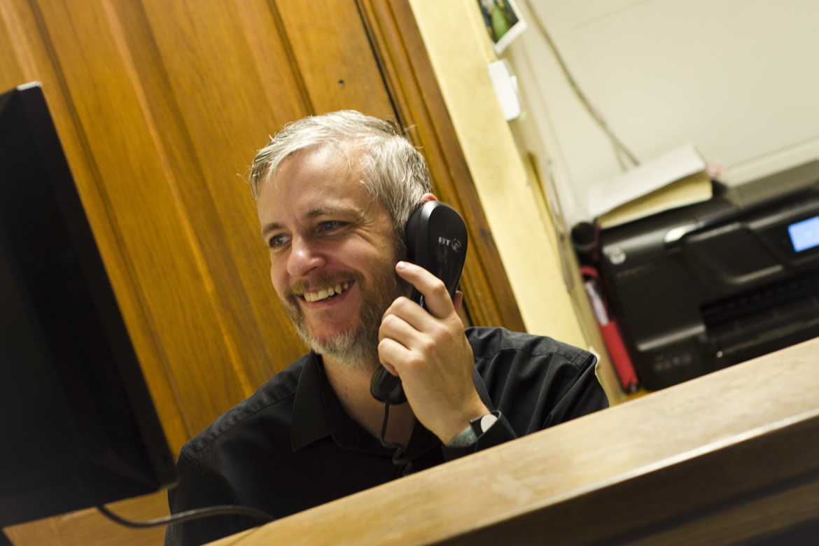 Member of staff talking on the telephone and smiling.