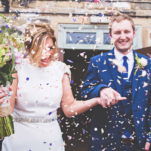 A newly married couple being showered with confetti - photographed by John Anderson Photography