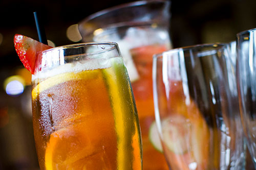 A glass of Pimms and Lemonade decorated with fruit